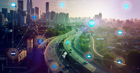 A city skyline with elevated highway traffic and glowing IoT network icons connecting buildings and roads.